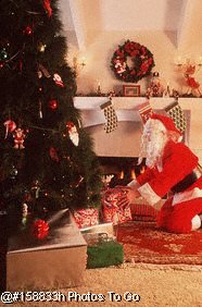 Santa Claus placing gifts under tree
